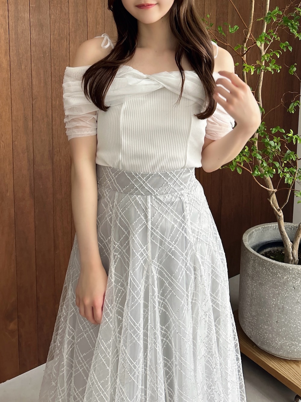 グレー系のスカート、ホワイト系のパンプス、ブラウン系のショルダーバッグを着用したレディースの夏コーディネートの8枚目の写真