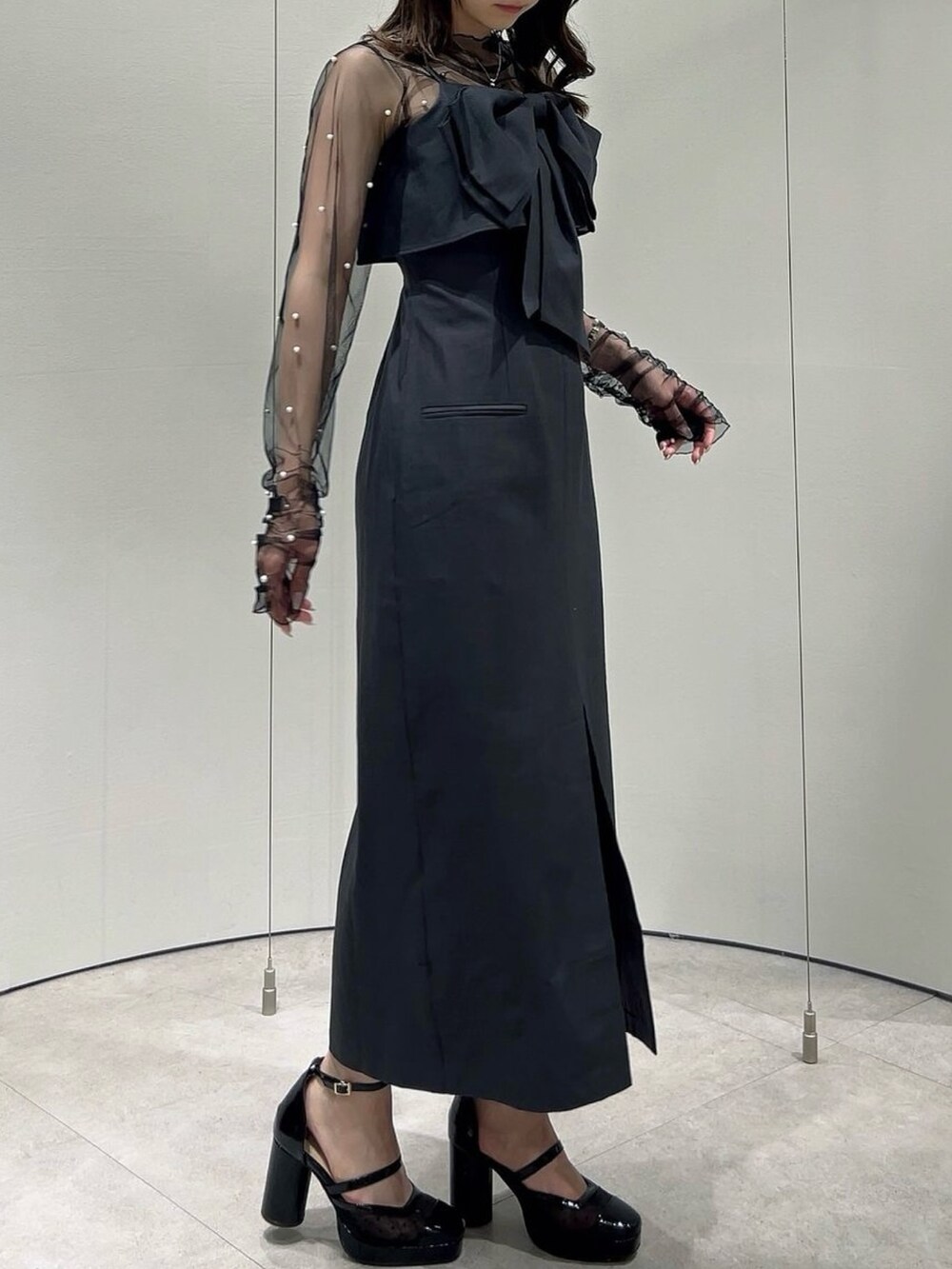 ブラック系のパンプス、ブラック系のTシャツ/カットソー、グレー系のワンピースを着用したレディースの秋コーディネートの4枚目の写真