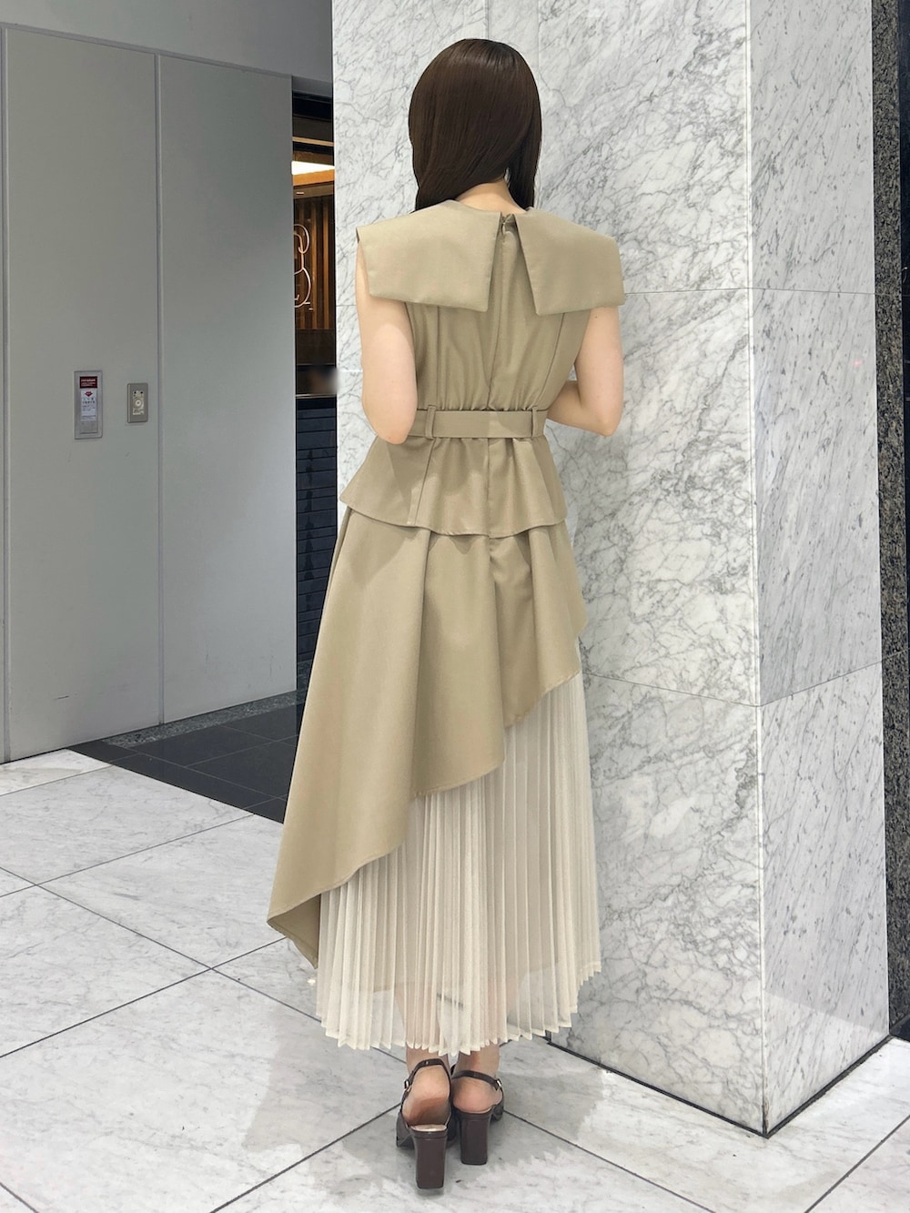 ベージュ系のワンピース、ブラウン系のローファーを着用したレディースの春コーディネートの5枚目の写真