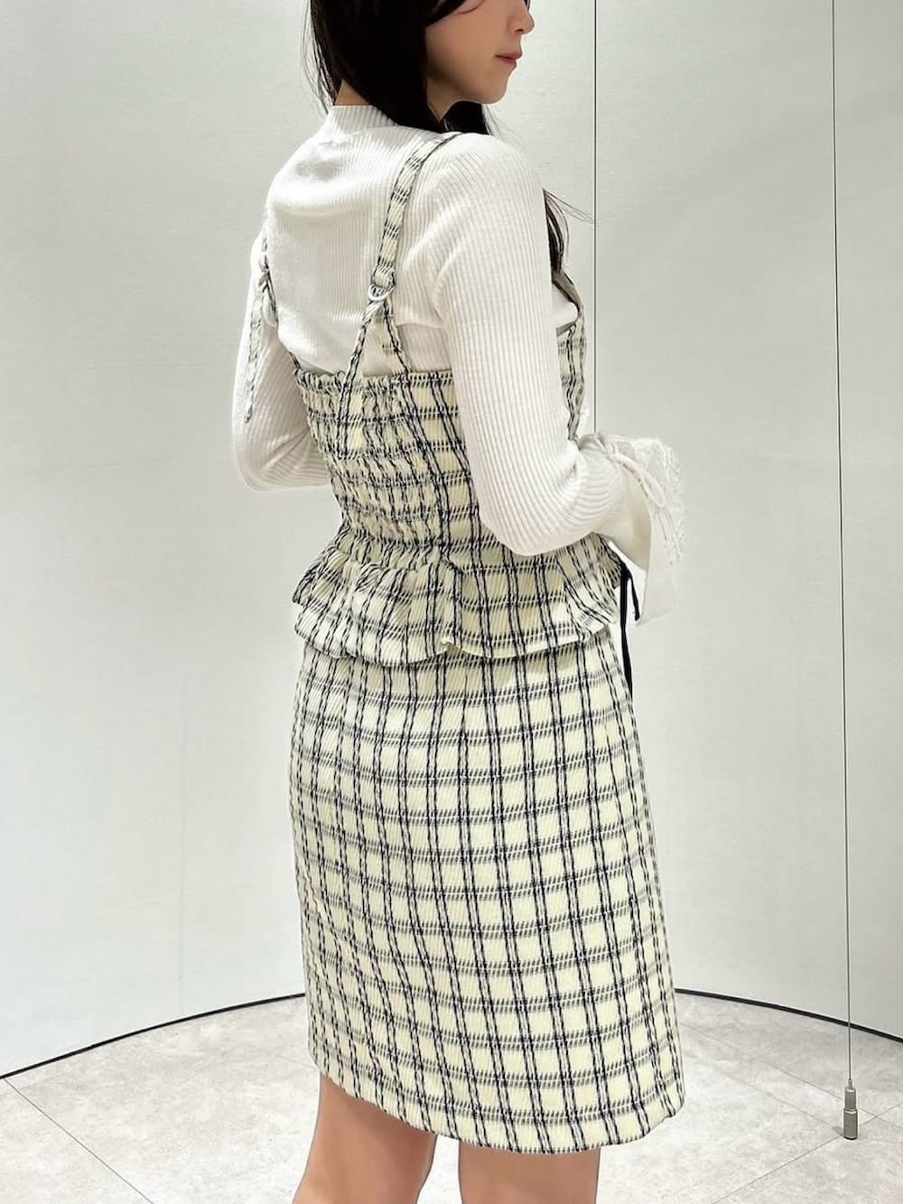 ホワイト系のニット/セーター、ホワイト系のワンピース、その他のブーツを着用したレディースの冬コーディネートの10枚目の写真