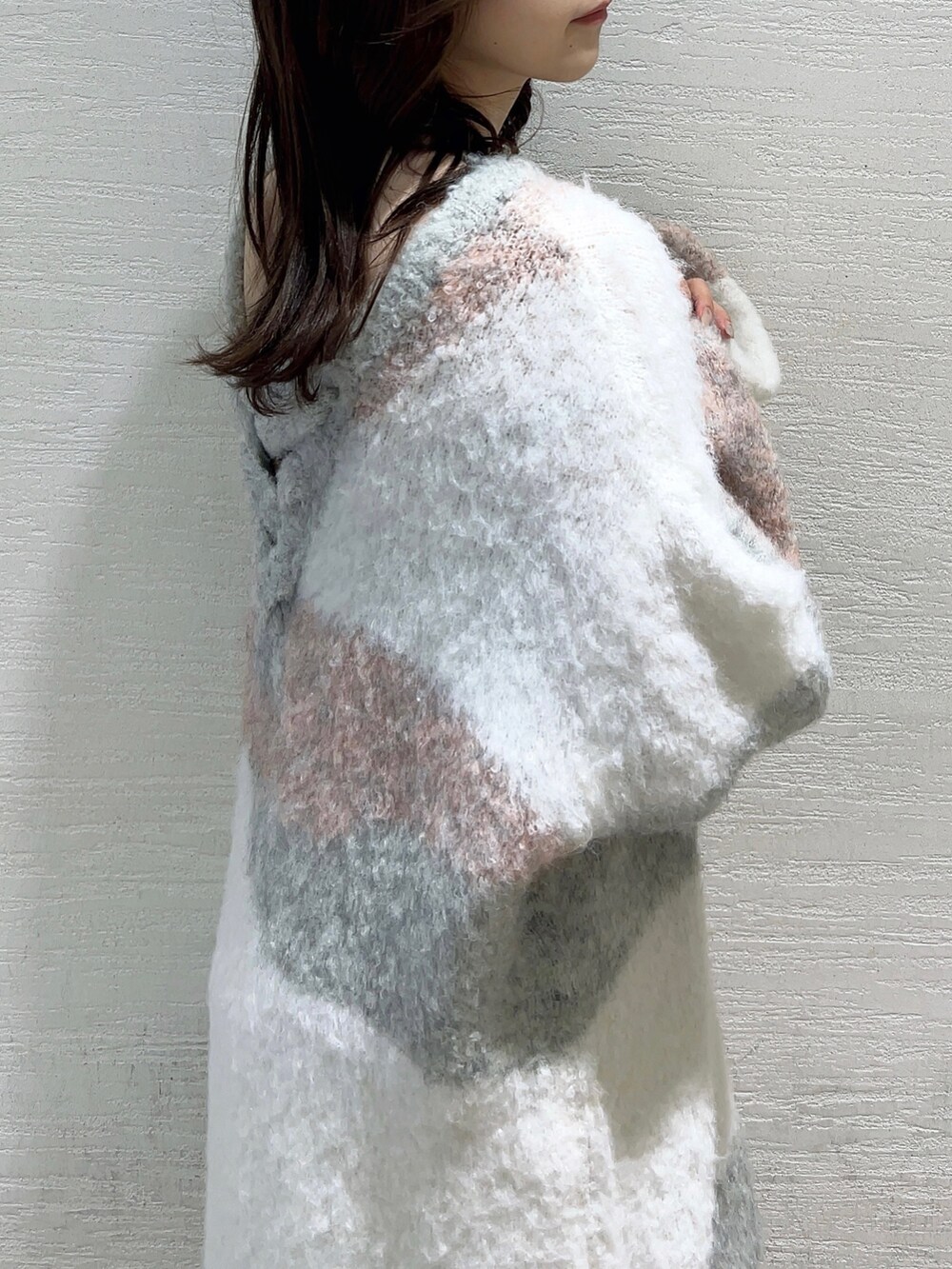 ピンク系のニット/セーター、ホワイト系のスカート、ベージュ系のブーツを着用したレディースの冬コーディネートの9枚目の写真