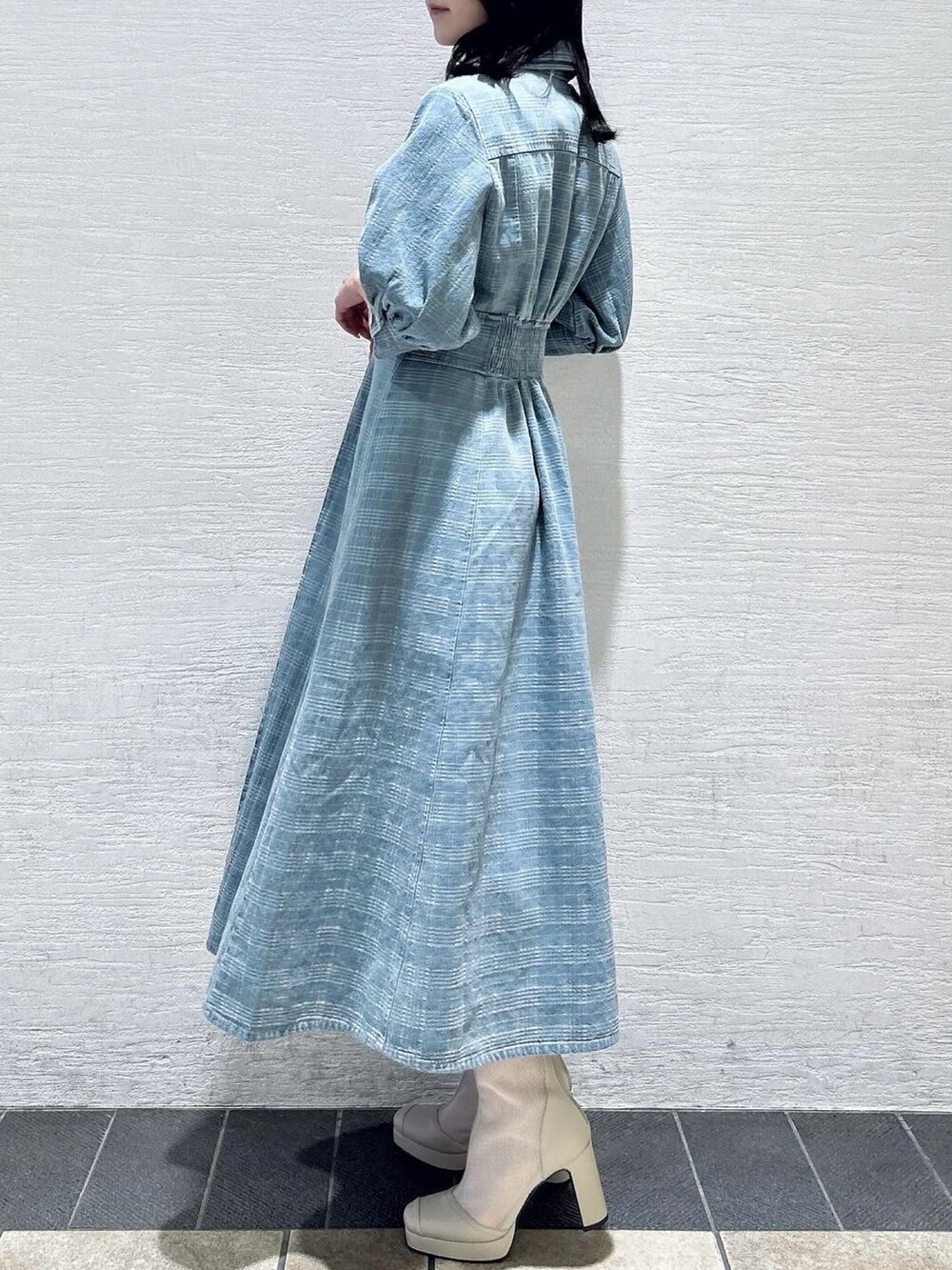 ブルー系のワンピース、ホワイト系のブーツを着用したレディースの冬コーディネートの5枚目の写真