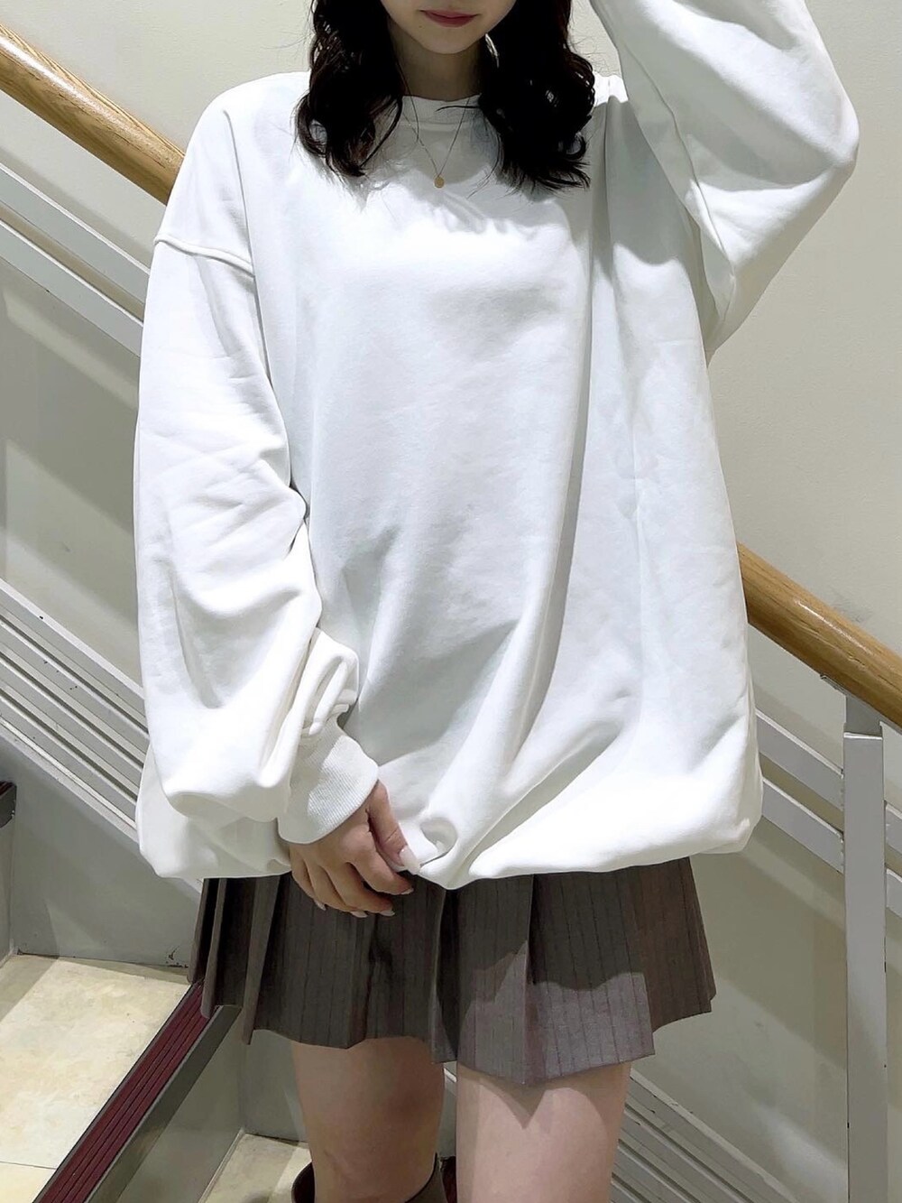 ホワイト系のTシャツ/カットソー、ベージュ系のスカート、ベージュ系のブーツを着用したレディースの冬コーディネートの7枚目の写真