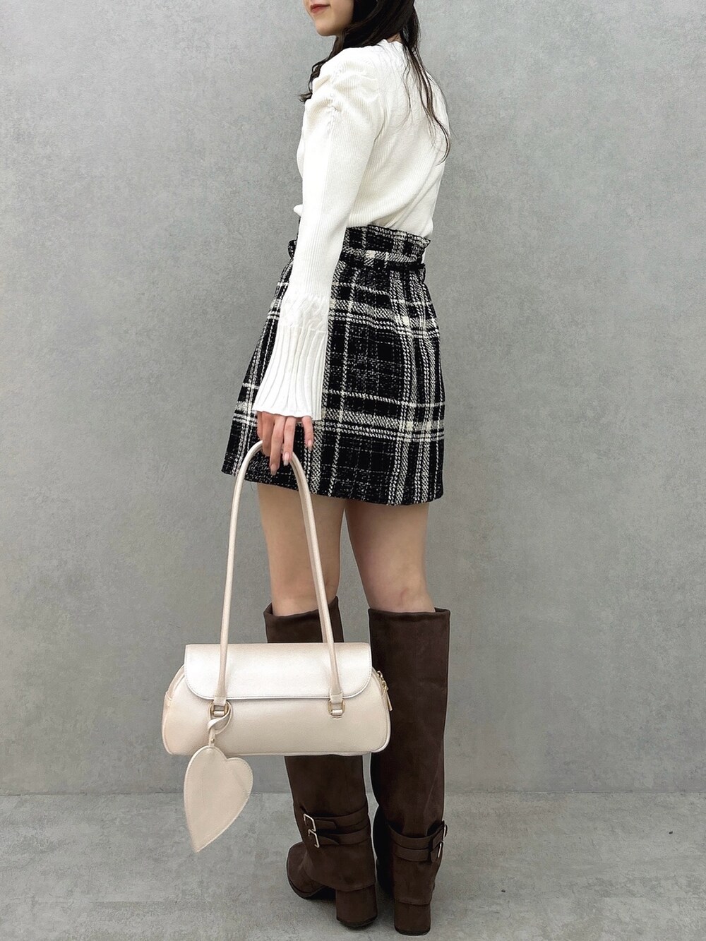 ホワイト系のニット/セーター、ブラック系のスカート、ブラック系のスカートを着用したレディースの冬コーディネートの4枚目の写真