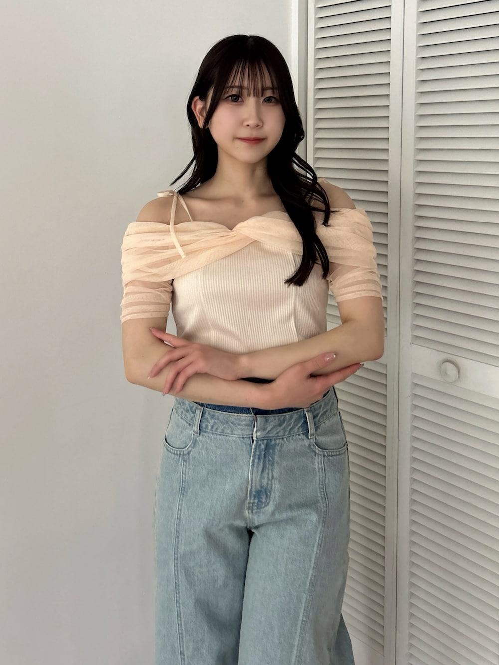 オレンジ系のTシャツ/カットソー、ホワイト系のパンプス、ブルー系のデニムパンツを着用したレディースの夏コーディネートの7枚目の写真