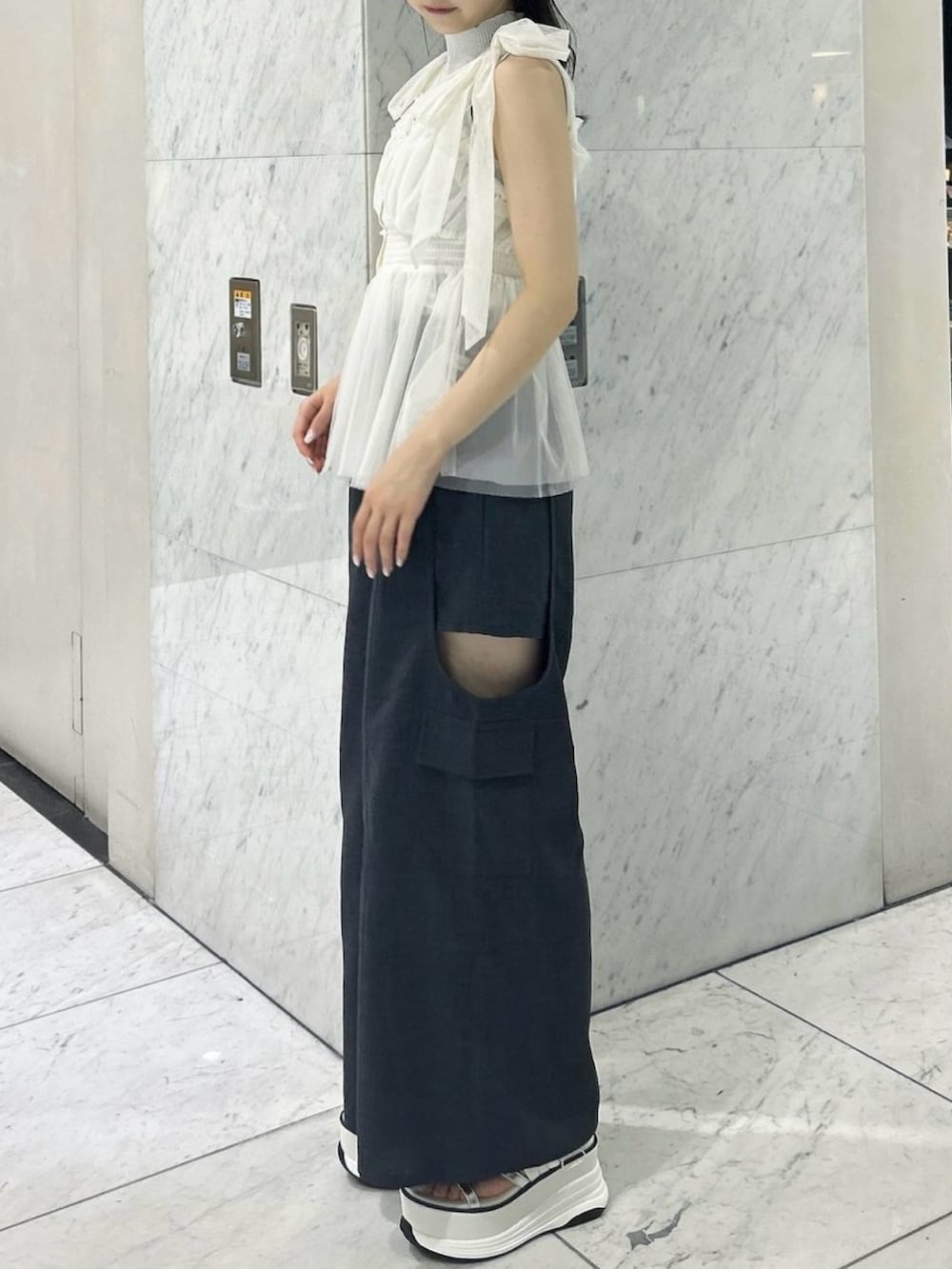 グレー系のニット/セーター、ホワイト系のタンクトップ、ホワイト系のサンダルを着用したレディースの夏コーディネートの3枚目の写真