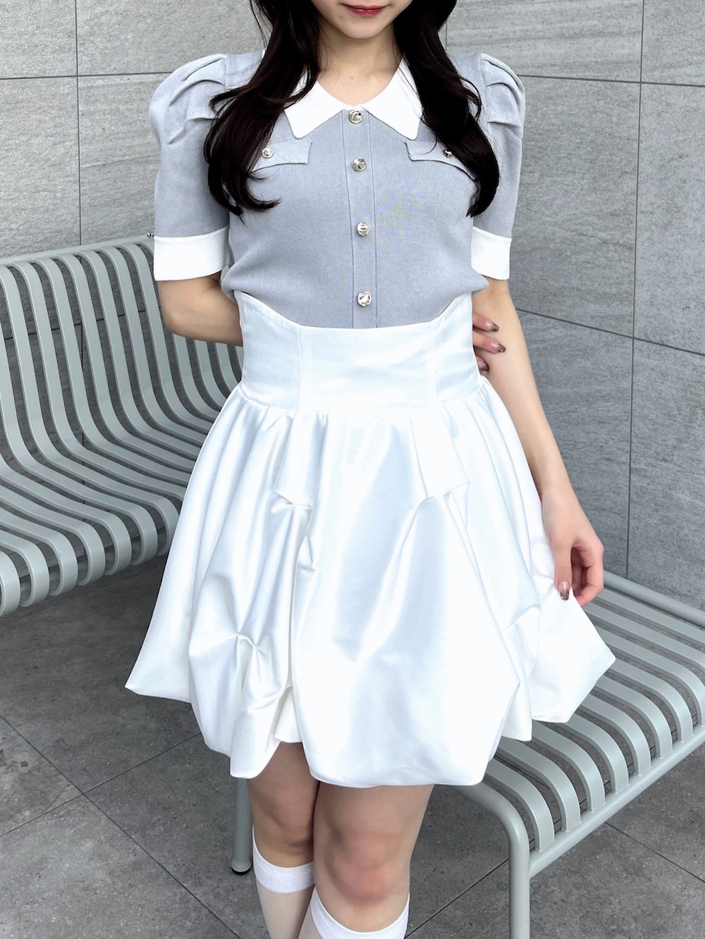 グレー系のニット/セーター、ホワイト系のスカートを着用したレディースの冬コーディネートの7枚目の写真