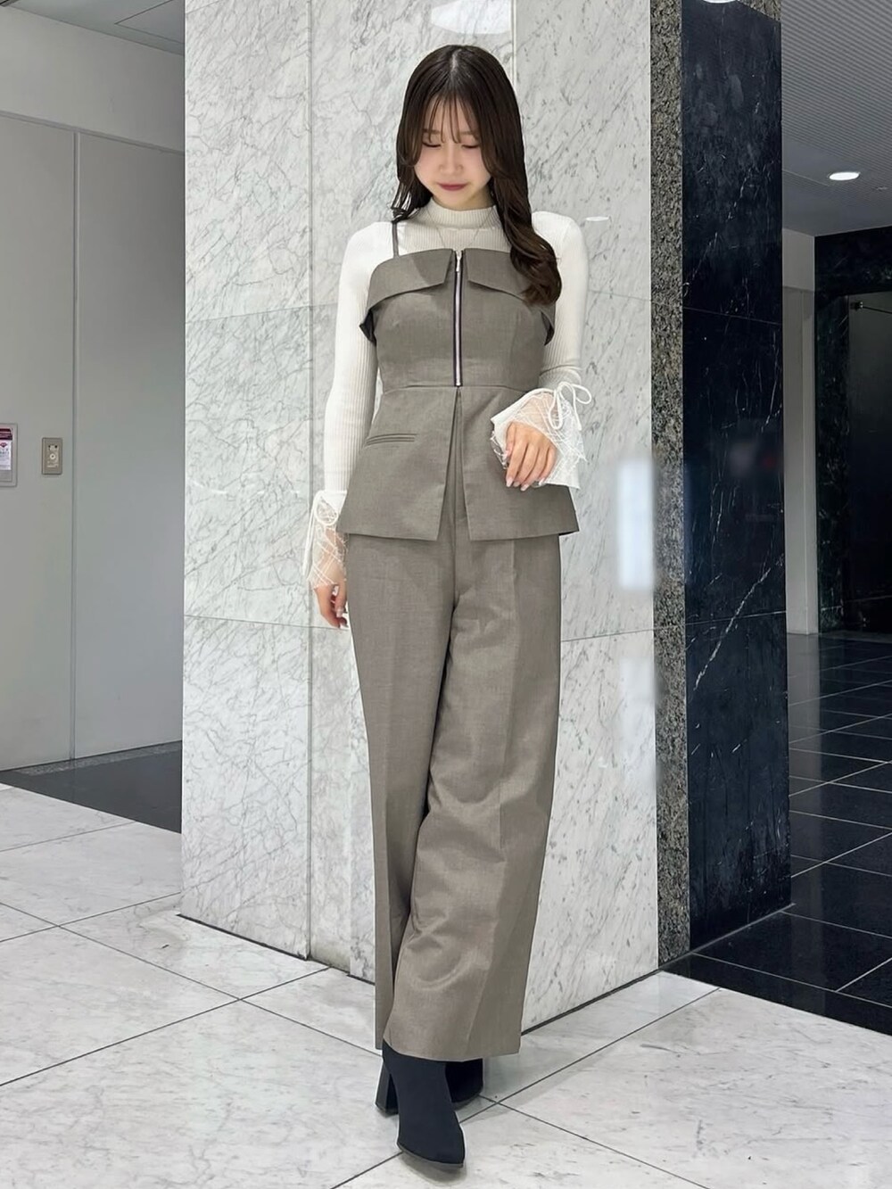 ホワイト系のニット/セーター、ブラウン系のつなぎ/オールインワン、その他のブーツを着用したレディースの冬コーディネートの2枚目の写真