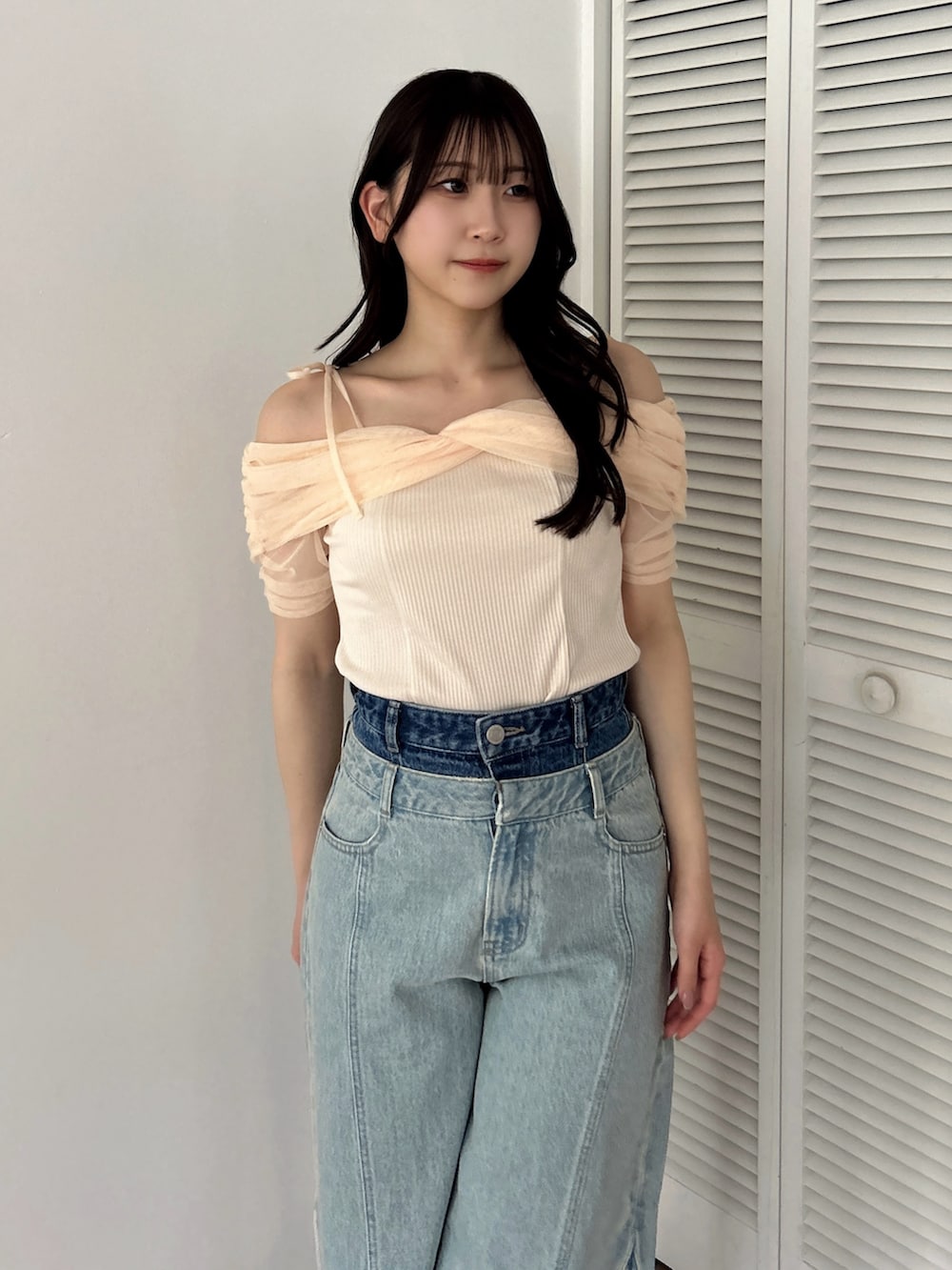 オレンジ系のTシャツ/カットソー、ホワイト系のパンプス、ブルー系のデニムパンツを着用したレディースの夏コーディネートの6枚目の写真
