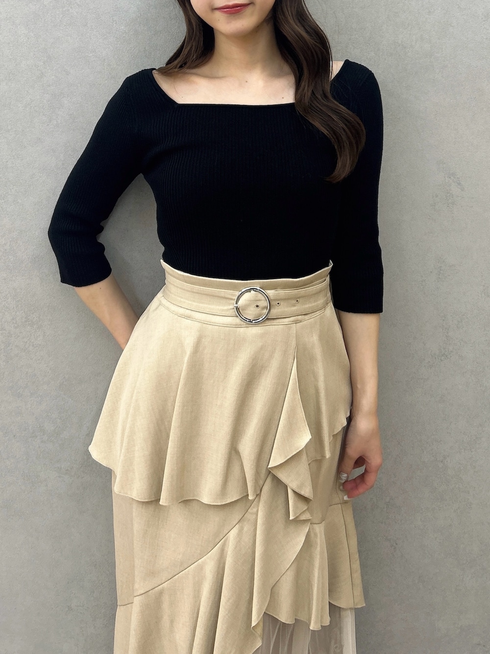 ブラック系のニット/セーター、ベージュ系のスカート、ブラック系のパンプスを着用したレディースの冬コーディネートの8枚目の写真