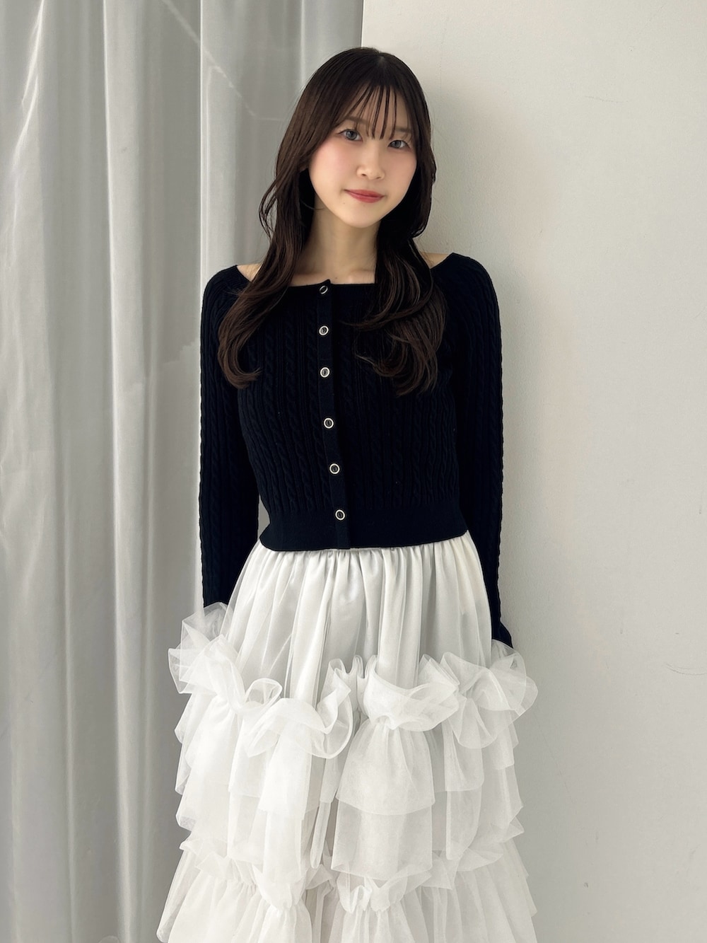 ブラック系のニット/セーター、ホワイト系のスカート、ブラック系のサンダルを着用したレディースの冬コーディネートの7枚目の写真