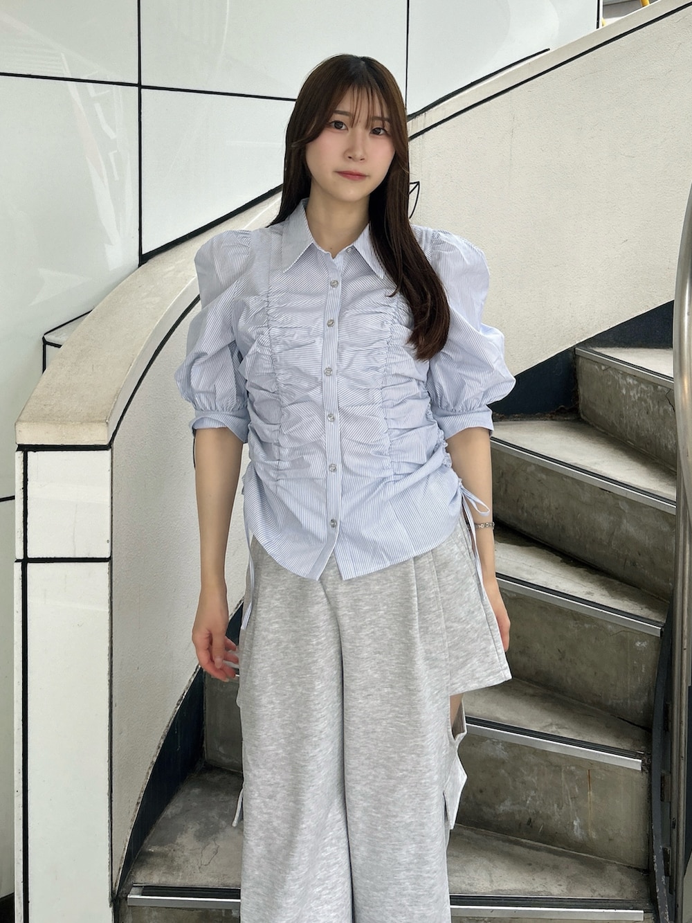 ブルー系のシャツ/ブラウス、グレー系のカーゴパンツ、ホワイト系のパンプスを着用したレディースの夏コーディネートの6枚目の写真