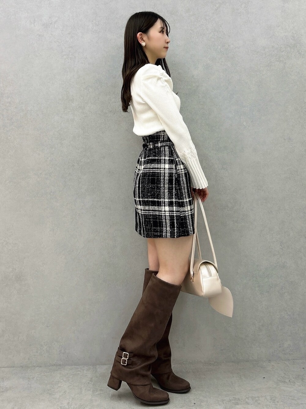 ホワイト系のニット/セーター、ブラック系のスカート、ブラック系のスカートを着用したレディースの冬コーディネートの3枚目の写真