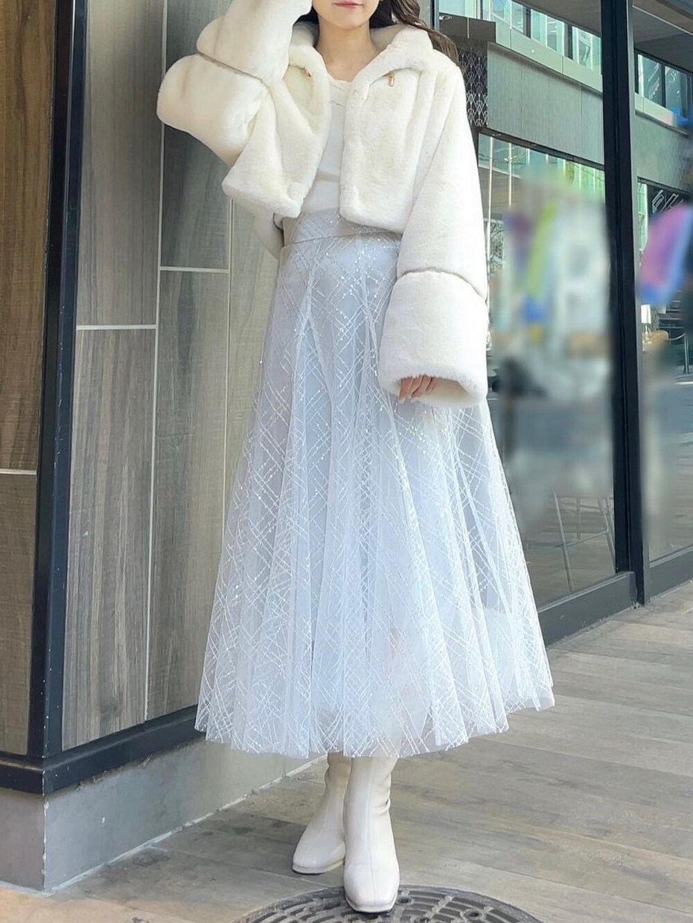 ホワイト系のその他アウター、ホワイト系のブーツ、ホワイト系のニット/セーターを着用したレディースの冬コーディネートの2枚目の写真