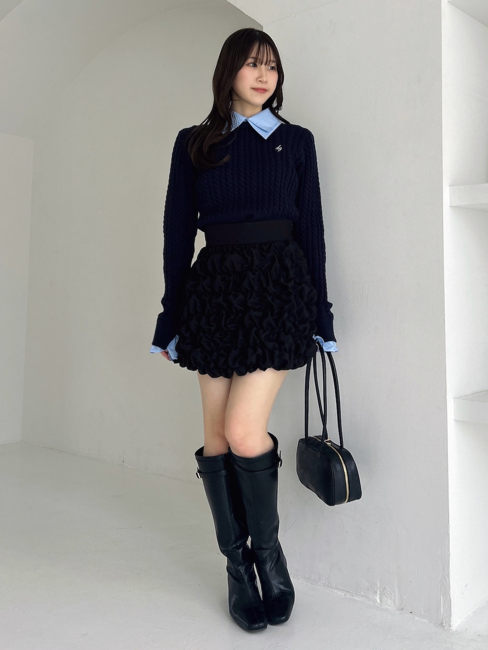 ブラック系のブーツ、ブラック系のスカート、ブルー系のニット/セーターを着用したレディースの冬コーディネートの4枚目の写真