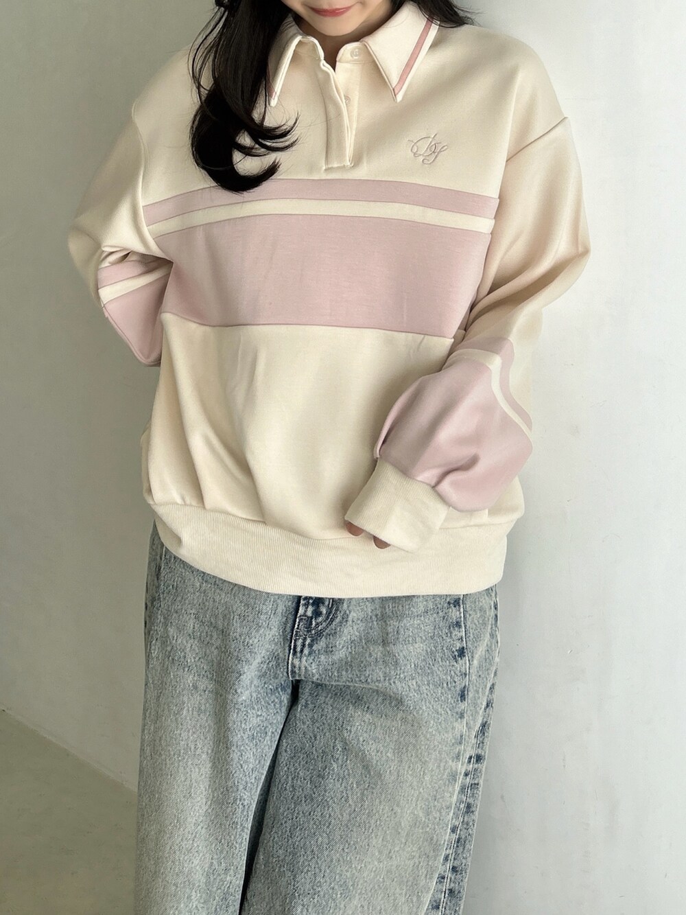 ブルー系のデニムパンツ、ホワイト系のハンドバッグ、ピンク系のスウェットを着用したレディースの冬コーディネートの9枚目の写真