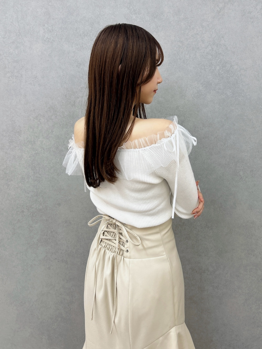 ホワイト系のニット/セーター、ホワイト系のスカート、ブラウン系のパンプスを着用したレディースの秋コーディネートの9枚目の写真