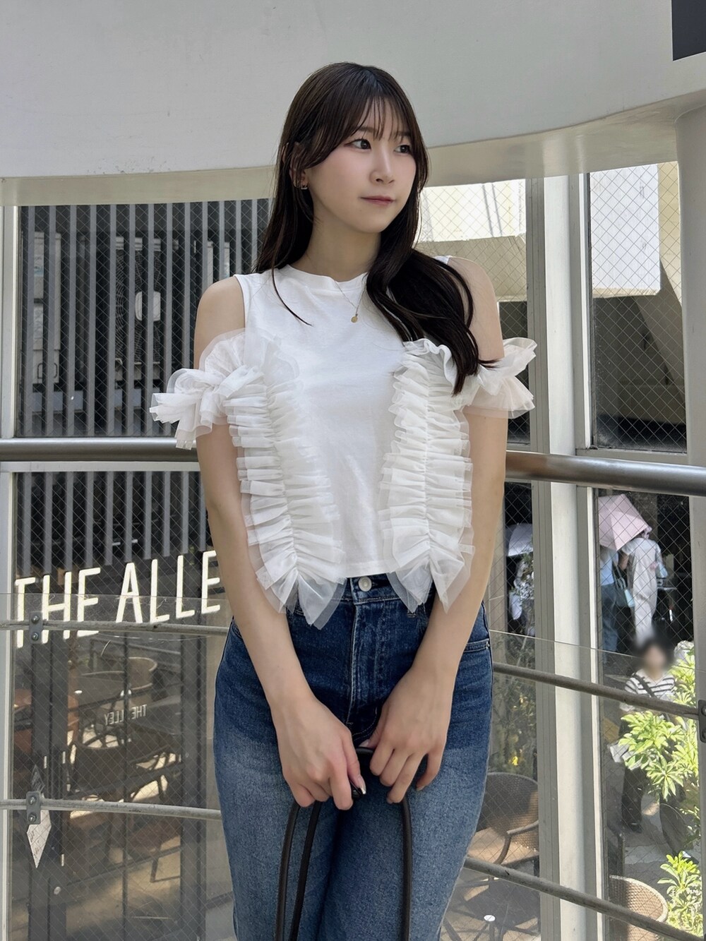 ホワイト系のTシャツ/カットソー、ブルー系のデニムパンツ、ホワイト系のサンダルを着用したレディースの夏コーディネートの6枚目の写真