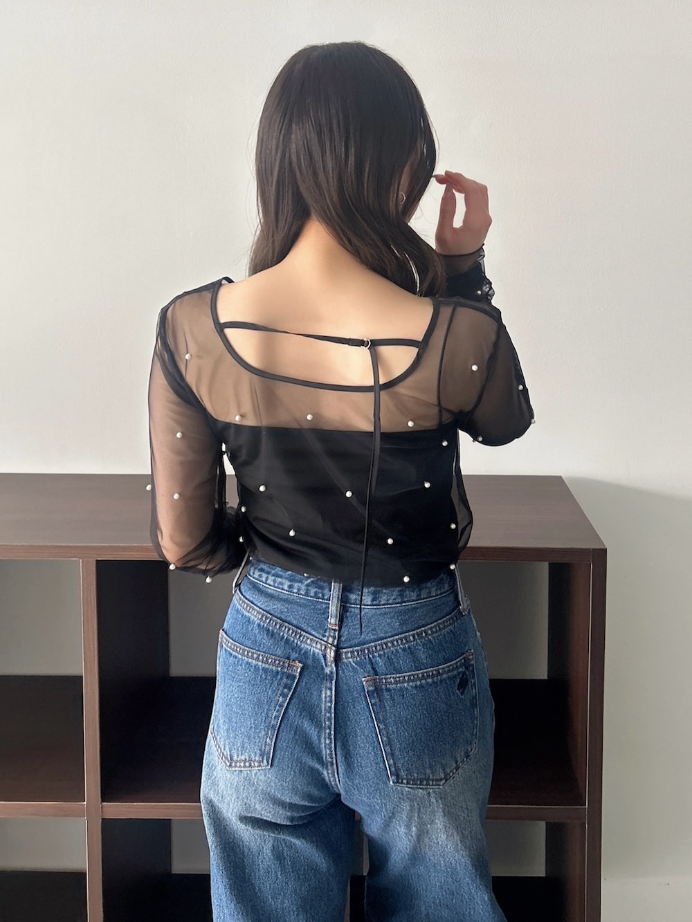 ブラック系のTシャツ/カットソー、ブルー系のデニムパンツを着用したレディースの春コーディネートの7枚目の写真