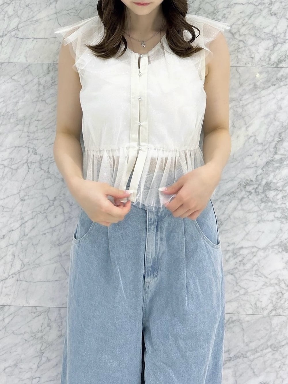 ホワイト系のタンクトップ、ホワイト系のキャミソール、ブルー系のデニムパンツを着用したレディースの夏コーディネートの7枚目の写真