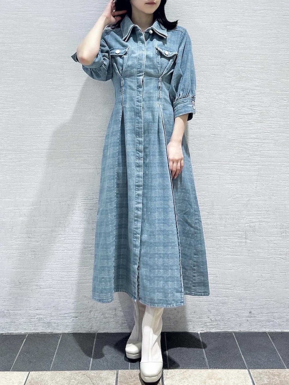 ブルー系のワンピース、ホワイト系のブーツを着用したレディースの冬コーディネートの2枚目の写真