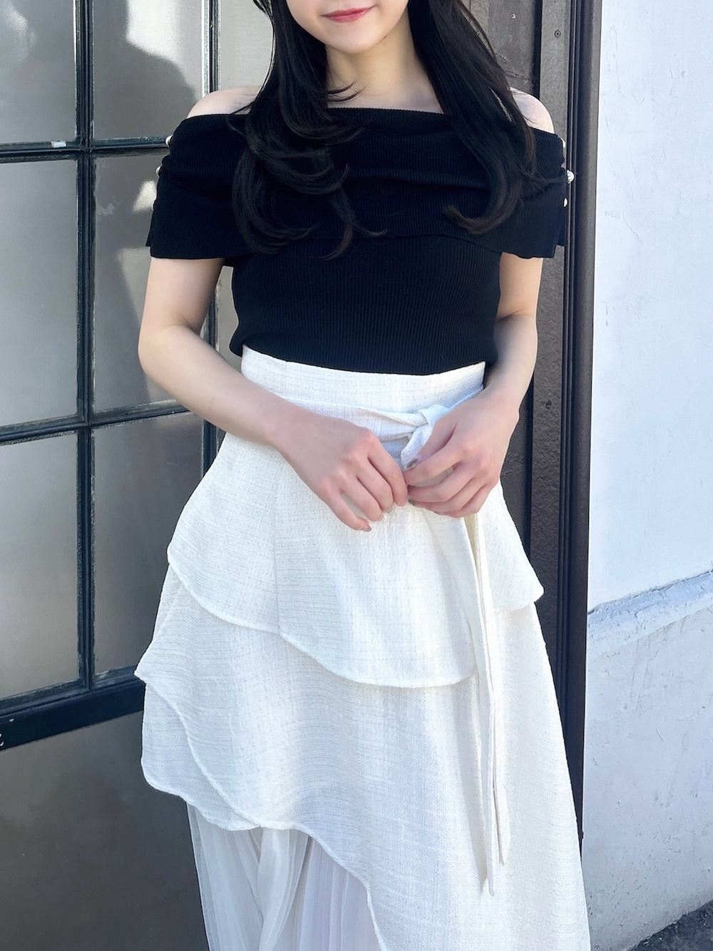 ホワイト系のスカート、ブラック系のニット/セーターを着用したレディースの冬コーディネートの6枚目の写真