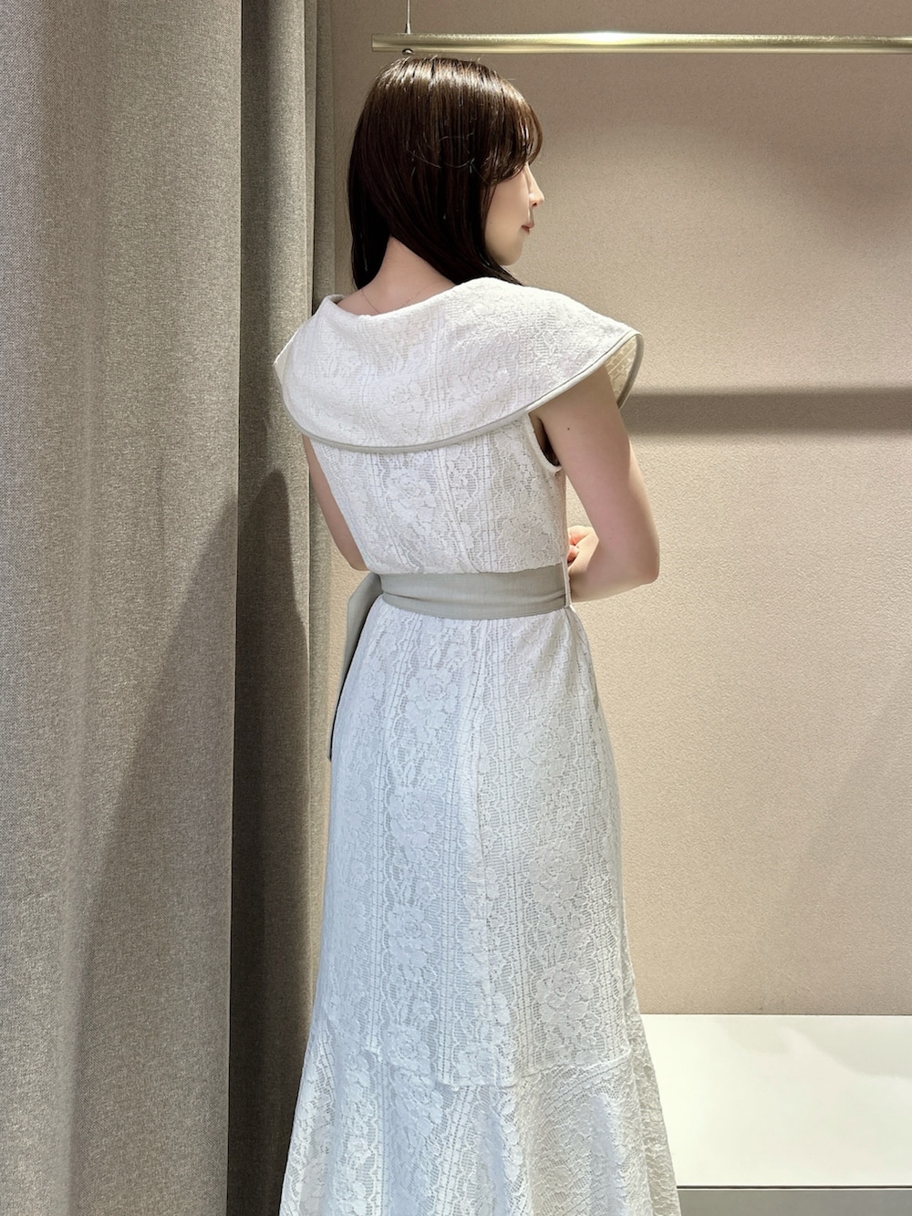 ホワイト系のワンピース、ホワイト系のサンダル、ブラック系のかごバッグを着用したレディースの夏コーディネートの10枚目の写真