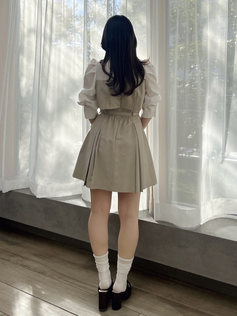 ベージュ系のワンピース、ブラウン系のパンプス、ブラウン系のハンドバッグを着用したレディースの春コーディネートの5枚目の写真