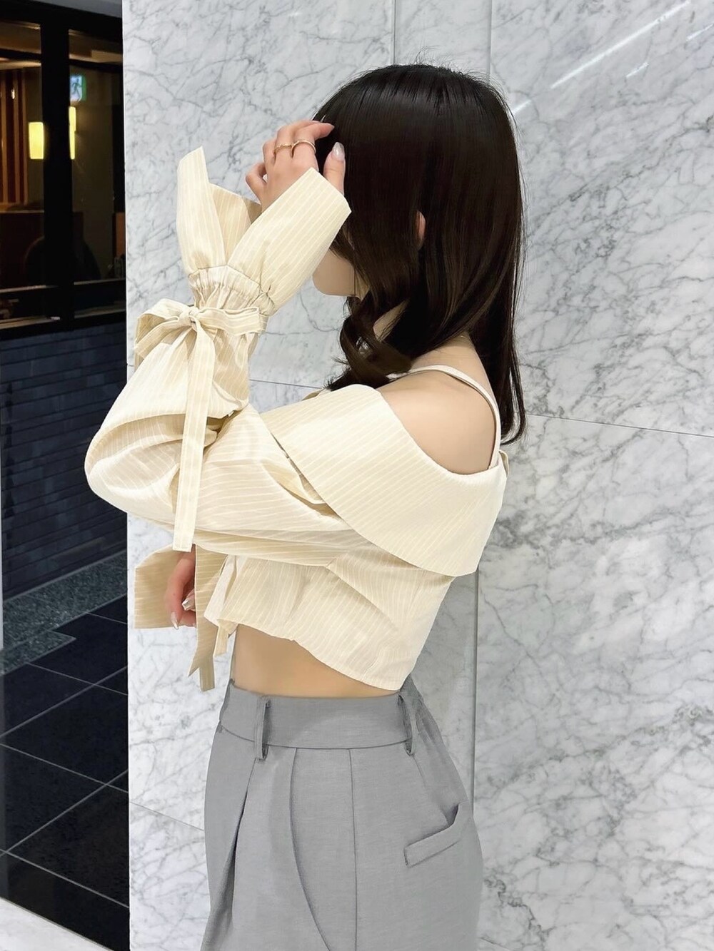 グレー系のスカート、シルバー系のパンプス、イエロー系のシャツ/ブラウスを着用したレディースの春コーディネートの10枚目の写真