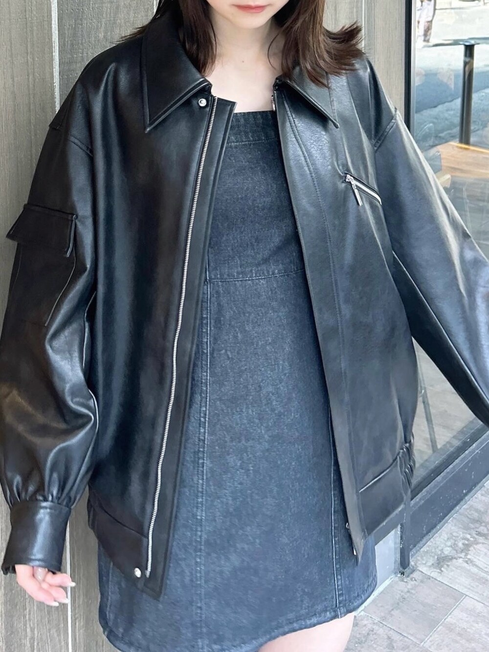 ブラック系のブルゾン、ブラック系のワンピース、ブラック系のブーツを着用したレディースの春コーディネートの7枚目の写真