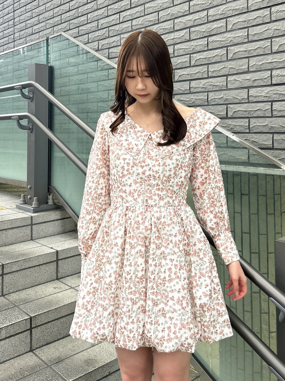 オレンジ系のワンピース、ブラウン系のローファーを着用したレディースの春コーディネートの5枚目の写真