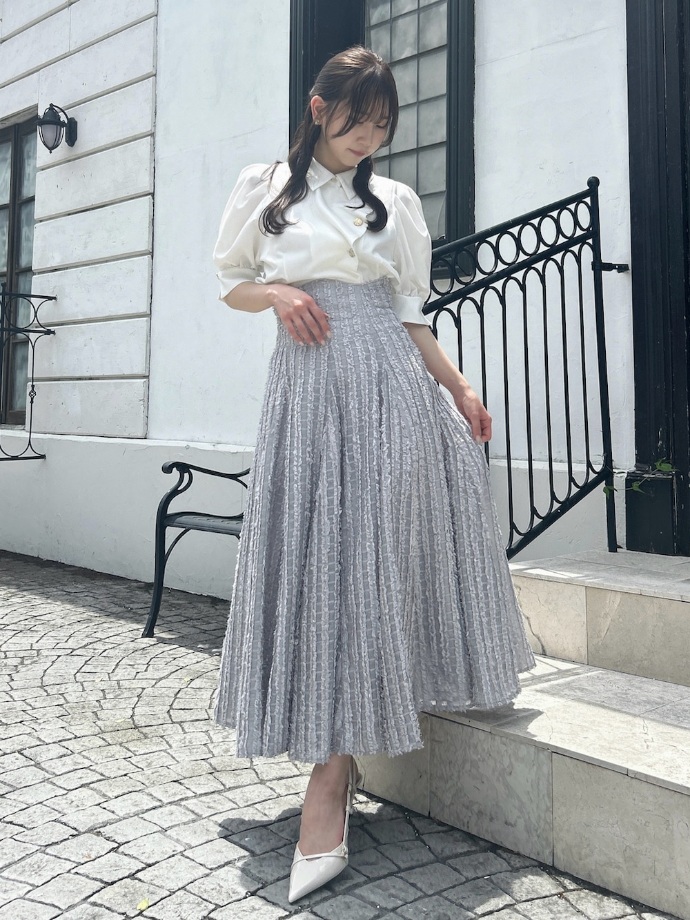 グレー系のスカート、ホワイト系のシャツ/ブラウスを着用したレディースの夏コーディネートの4枚目の写真