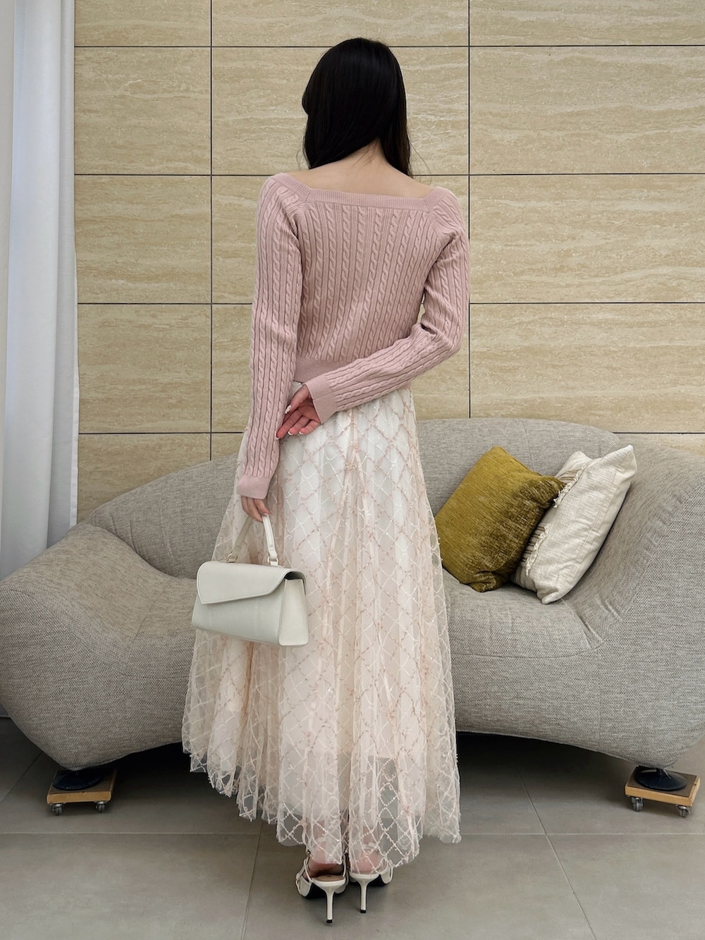 ピンク系のニット/セーター、ピンク系のスカートを着用したレディースの秋コーディネートの5枚目の写真