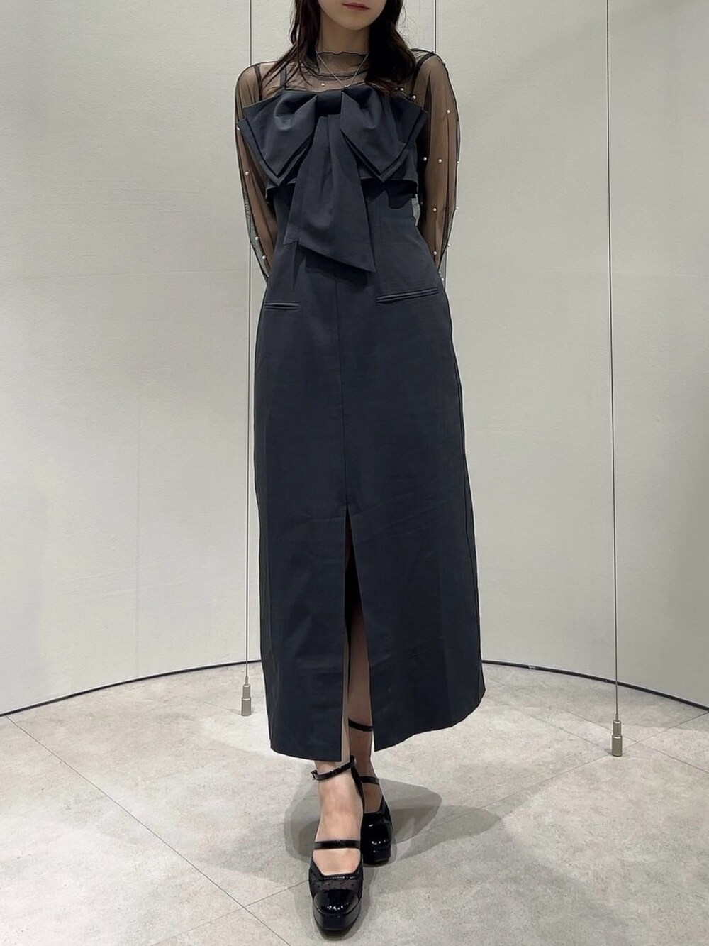 ブラック系のパンプス、ブラック系のTシャツ/カットソー、グレー系のワンピースを着用したレディースの秋コーディネートの2枚目の写真