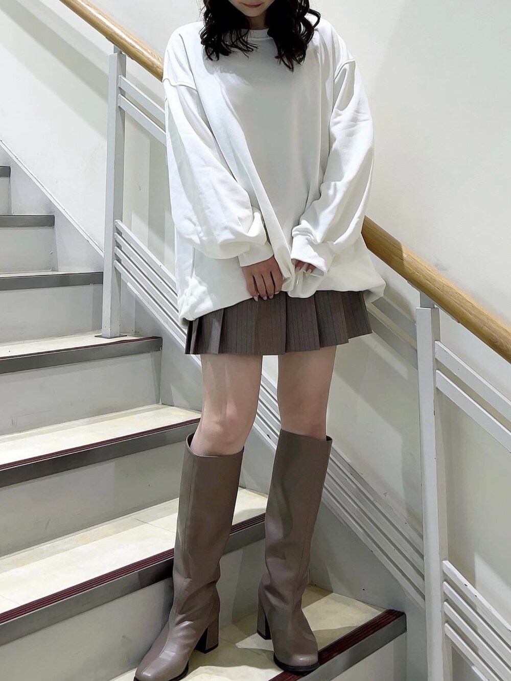 ホワイト系のTシャツ/カットソー、ベージュ系のスカート、ベージュ系のブーツを着用したレディースの冬コーディネートの2枚目の写真