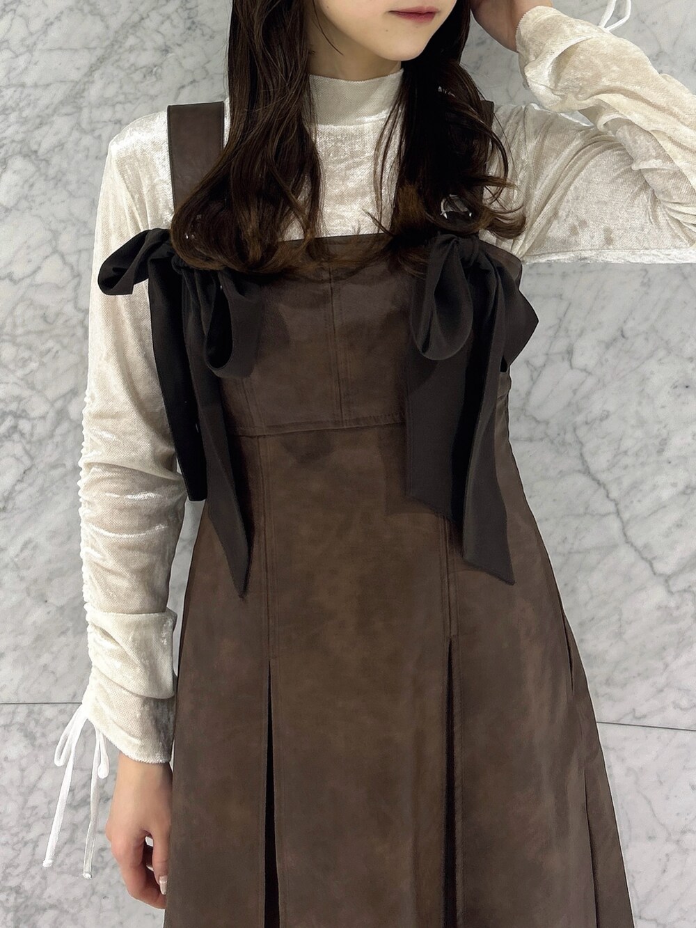ホワイト系のTシャツ/カットソー、ブラウン系のワンピース、その他のブーツを着用したレディースの冬コーディネートの8枚目の写真