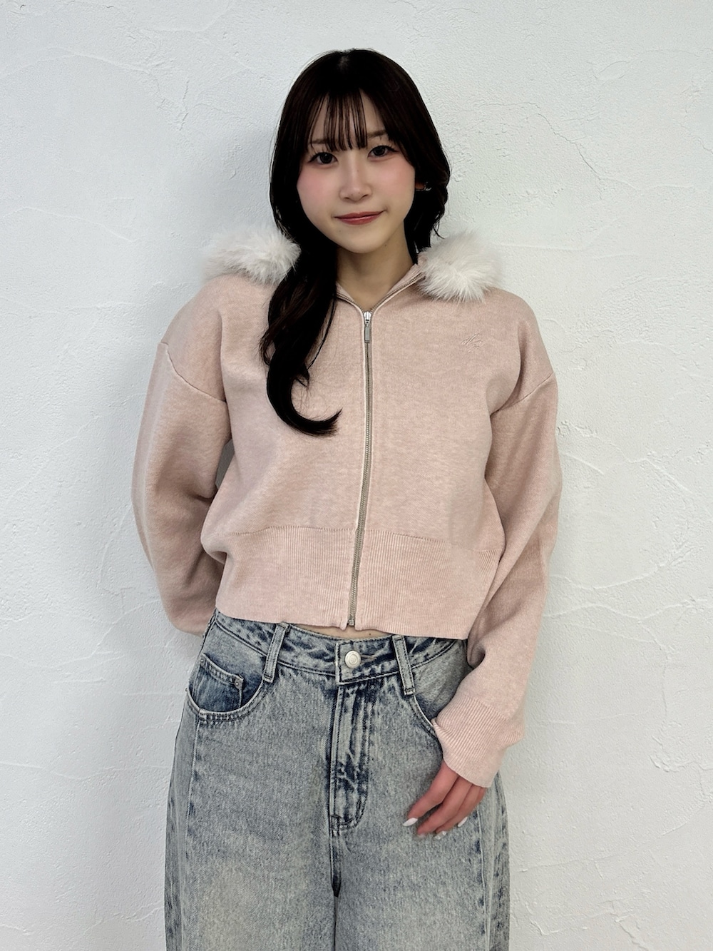 ピンク系のニット/セーター、ブルー系のデニムパンツを着用したレディースの冬コーディネートの8枚目の写真