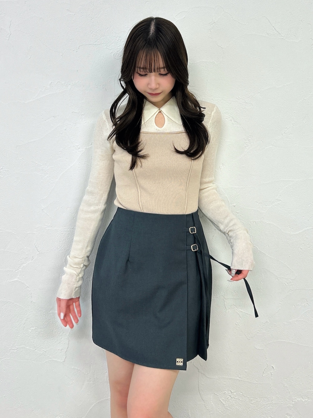 グレー系のスカート、ブラック系のブーツ、ベージュ系のニット/セーターを着用したレディースの春コーディネートの7枚目の写真