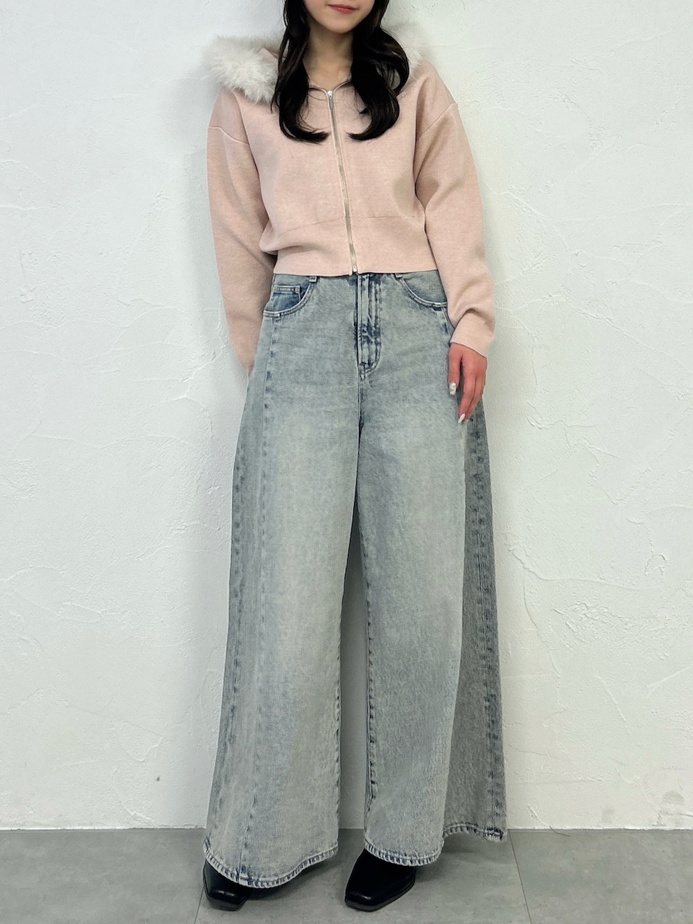 ピンク系のニット/セーター、ブルー系のデニムパンツを着用したレディースの冬コーディネートの2枚目の写真