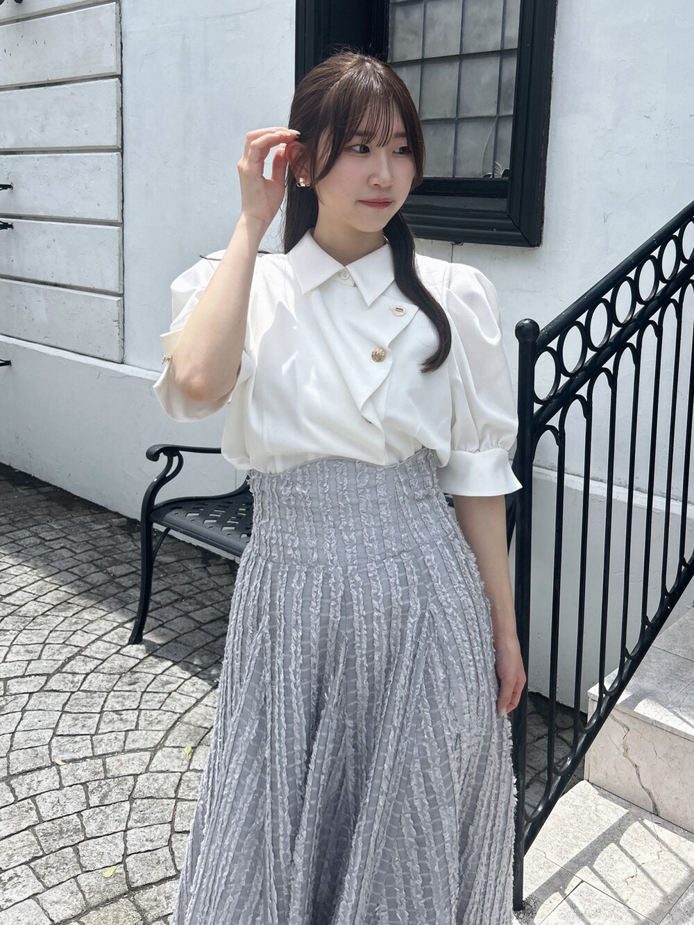 グレー系のスカート、ホワイト系のシャツ/ブラウスを着用したレディースの夏コーディネートの6枚目の写真