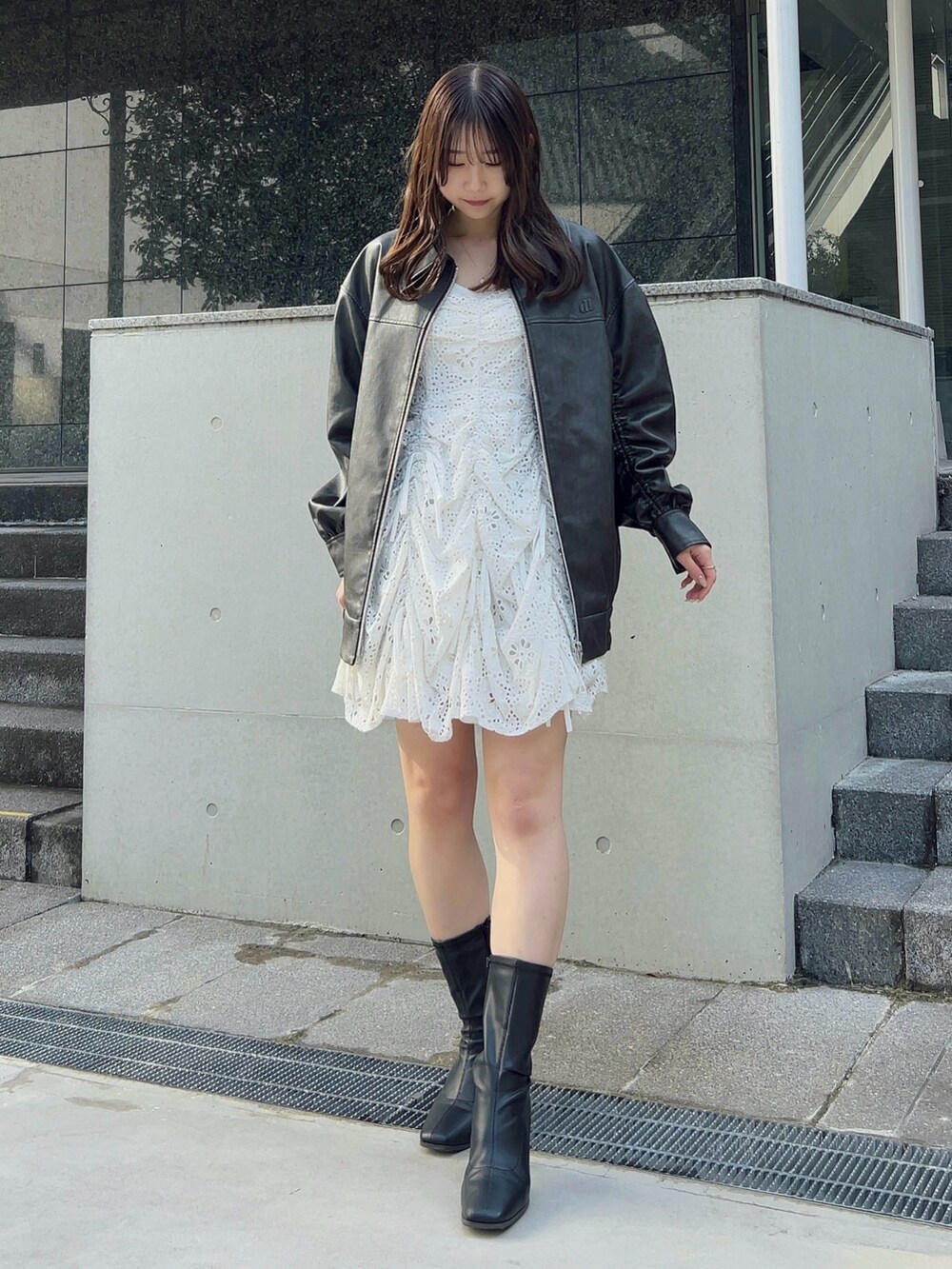 ブラック系のブルゾン、ホワイト系のワンピースを着用したレディースの冬コーディネートの2枚目の写真