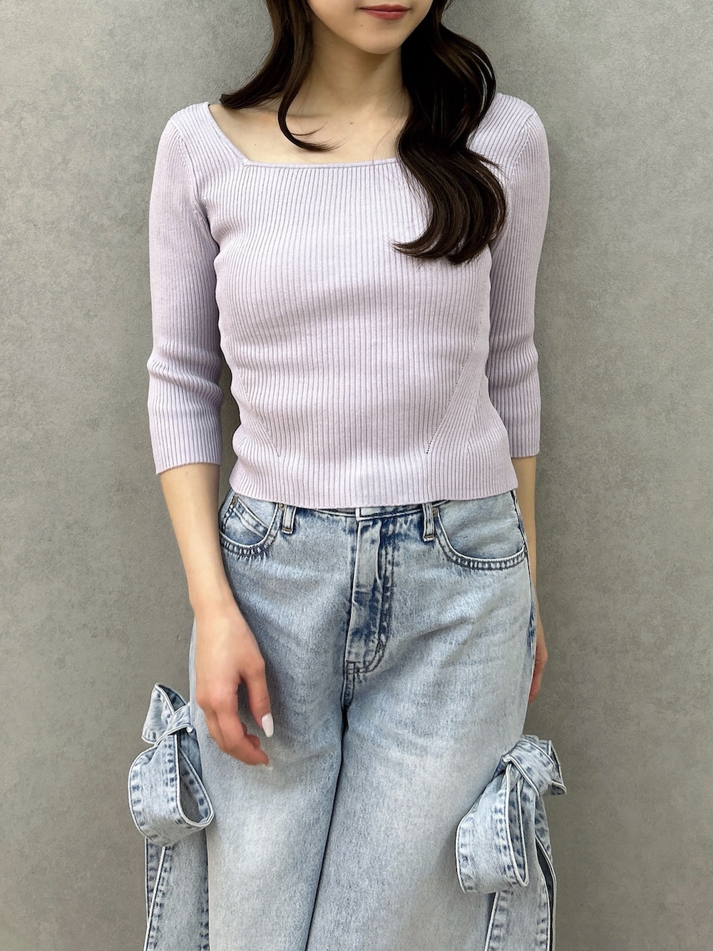 パープル系のニット/セーター、ブルー系のデニムパンツ、ホワイト系のパンプスを着用したレディースの冬コーディネートの6枚目の写真