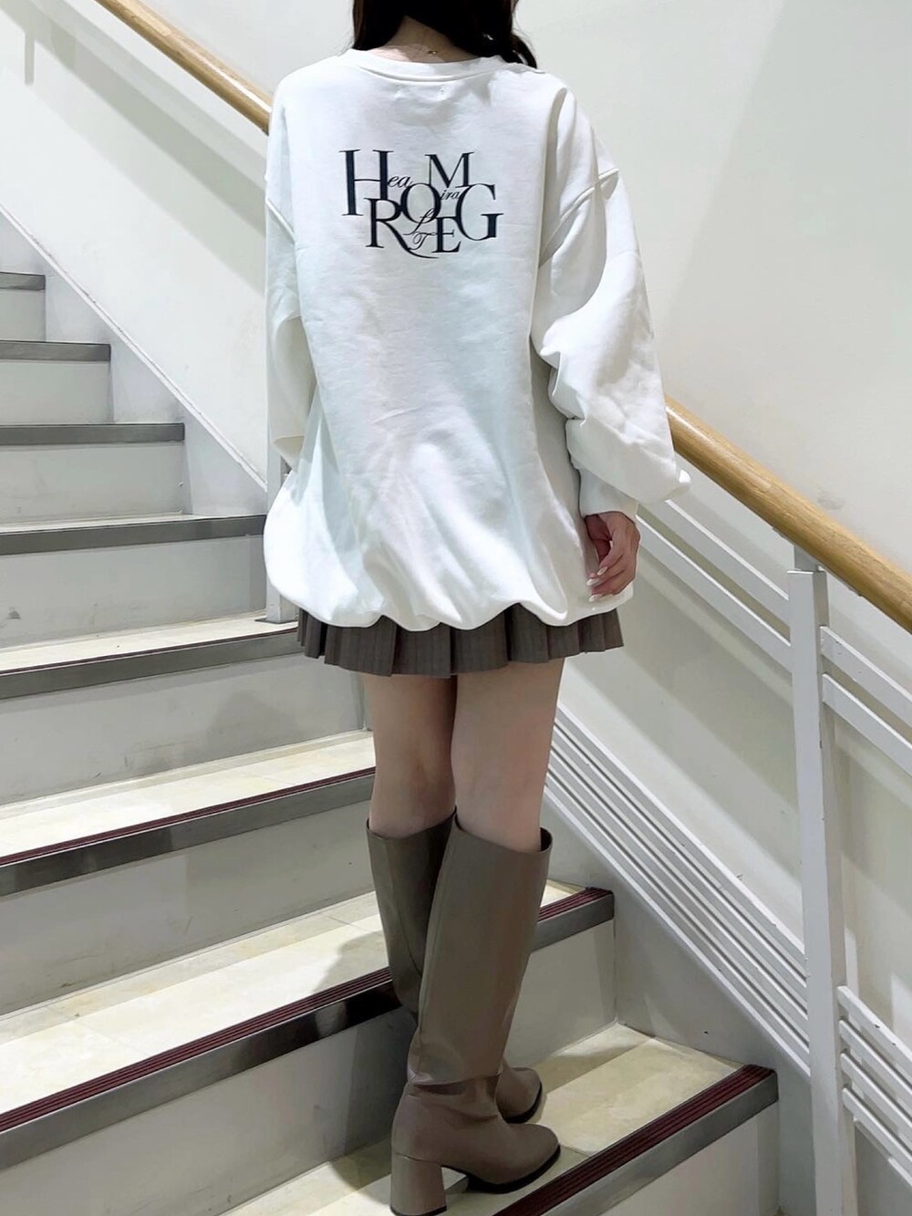ホワイト系のTシャツ/カットソー、ベージュ系のスカート、ベージュ系のブーツを着用したレディースの冬コーディネートの5枚目の写真