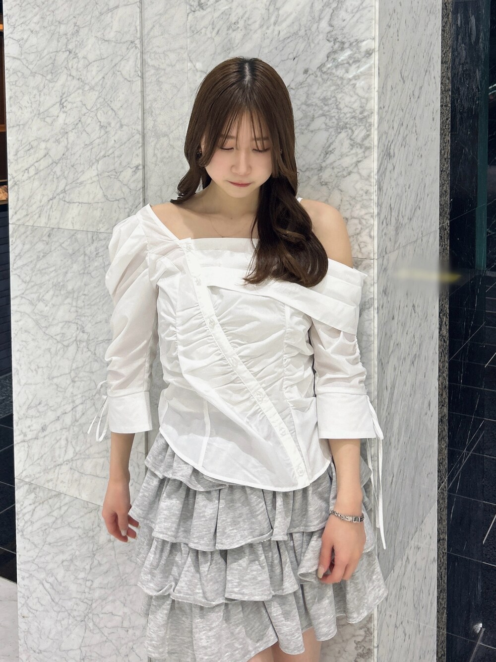 グレー系のスカート、ブルー系のハンドバッグ、ベージュ系のブーツを着用したレディースの春コーディネートの8枚目の写真