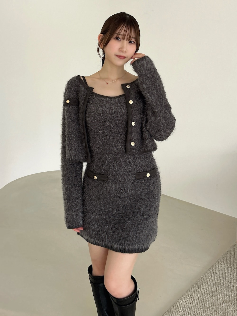 グレー系のノーカラージャケット、グレー系のワンピース、ブラック系のブーツを着用したレディースの冬コーディネートの8枚目の写真