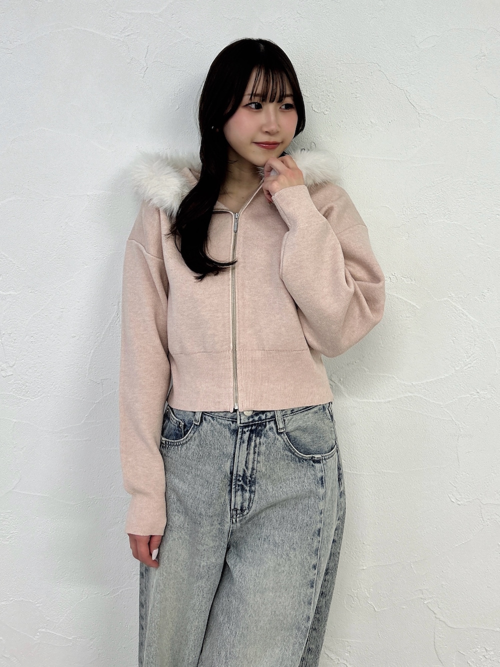 ピンク系のニット/セーター、ブルー系のデニムパンツを着用したレディースの冬コーディネートの7枚目の写真