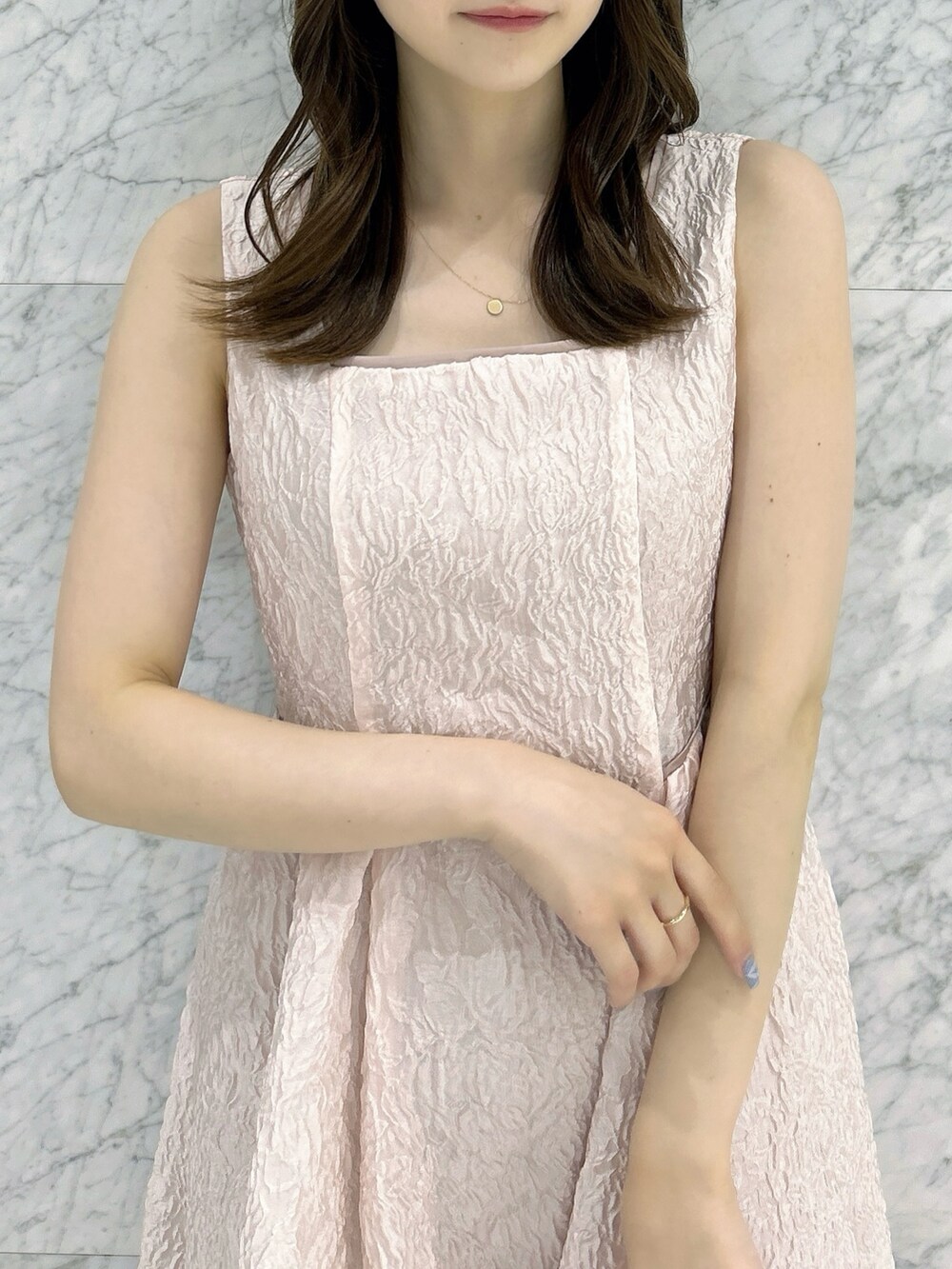 ホワイト系のパンプス、ホワイト系のハンドバッグ、ピンク系のドレスを着用したレディースの夏コーディネートの9枚目の写真