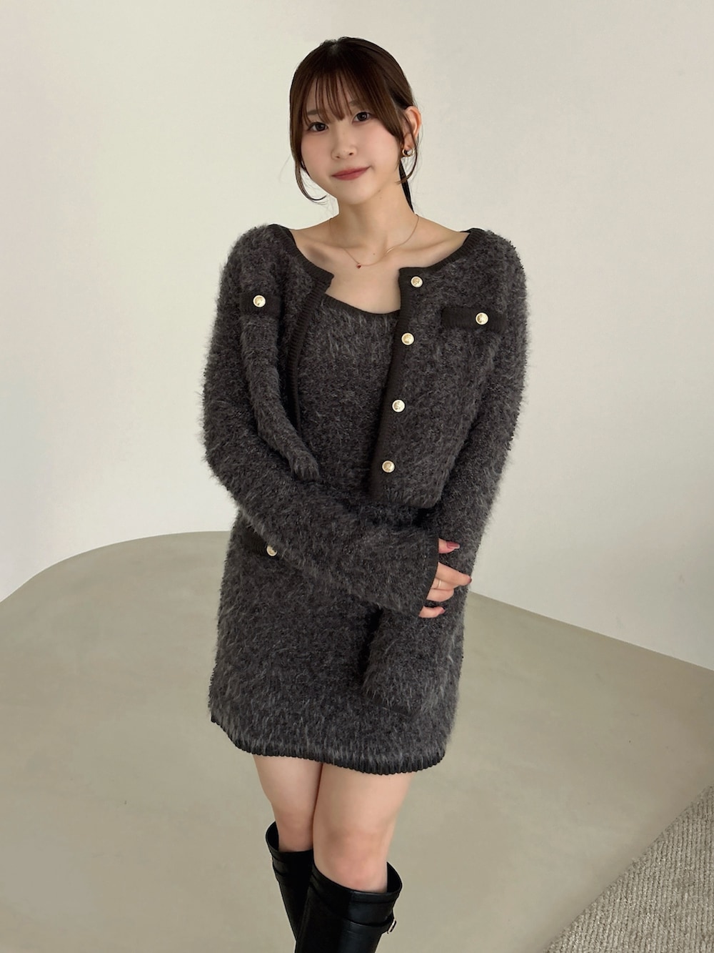 グレー系のノーカラージャケット、グレー系のワンピース、ブラック系のブーツを着用したレディースの冬コーディネートの6枚目の写真