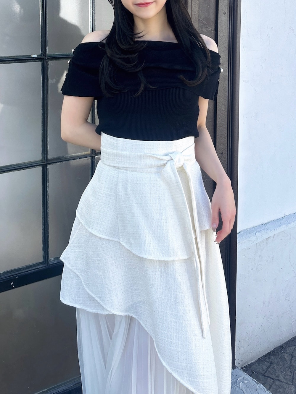 ホワイト系のスカート、ブラック系のニット/セーターを着用したレディースの冬コーディネートの7枚目の写真