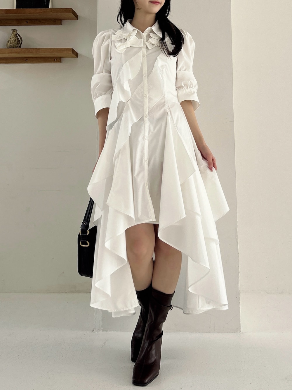 ホワイト系のワンピース、ブラウン系のブーツを着用したレディースの冬コーディネートの3枚目の写真